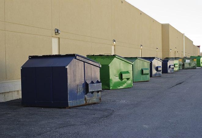 a construction worker disposing of debris into a dumpster in Afton